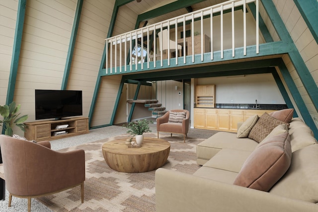 carpeted living area with a sink and stairs