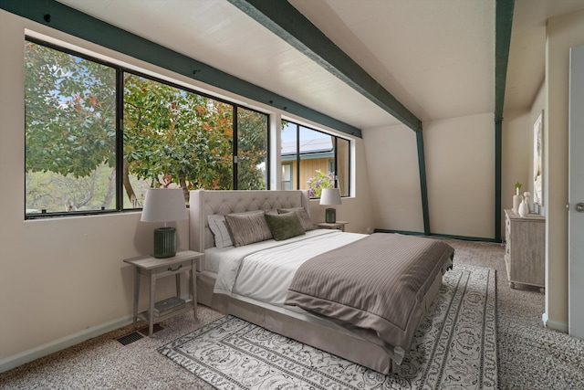 carpeted bedroom with baseboards and beamed ceiling
