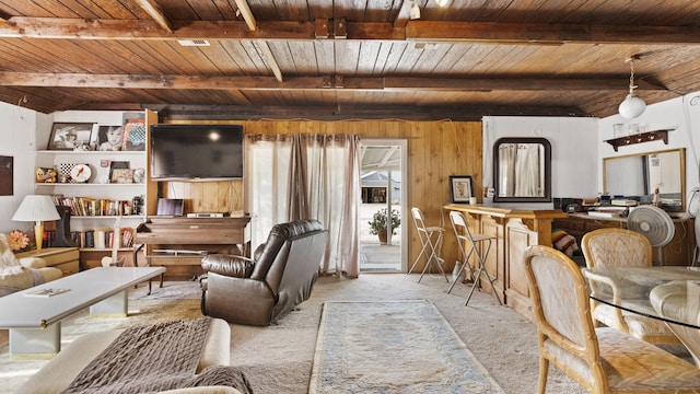 living area with carpet, wooden ceiling, and beam ceiling