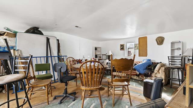 dining area featuring concrete flooring, vaulted ceiling, and visible vents