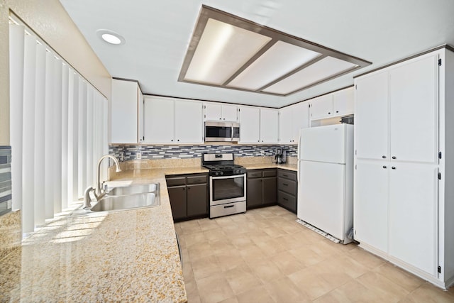 kitchen featuring tasteful backsplash, sink, white cabinets, and stainless steel appliances