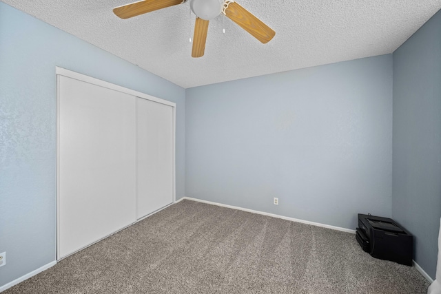 unfurnished bedroom featuring a textured ceiling, carpet floors, a closet, and ceiling fan