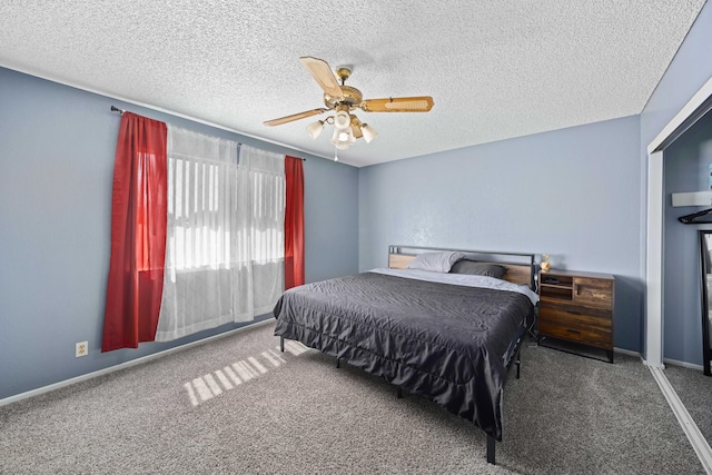 bedroom with ceiling fan, carpet, and a textured ceiling