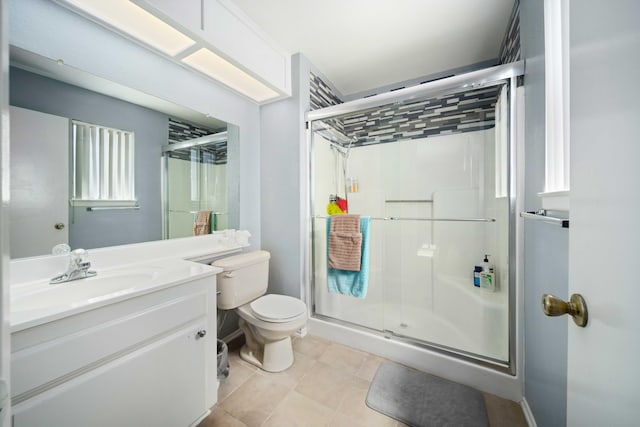 bathroom with tile patterned flooring, vanity, an enclosed shower, and toilet