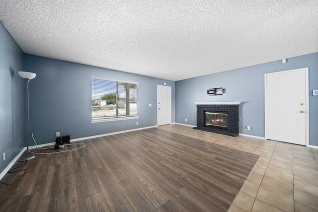 unfurnished living room featuring a fireplace, hardwood / wood-style floors, and a textured ceiling