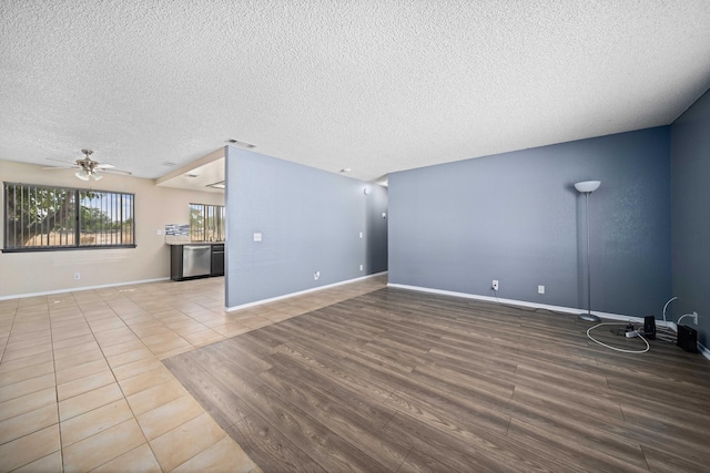 unfurnished living room with tile patterned flooring, a textured ceiling, and ceiling fan