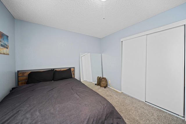 carpeted bedroom with a textured ceiling and a closet