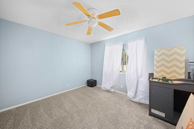 interior space with a textured ceiling, carpet floors, and ceiling fan