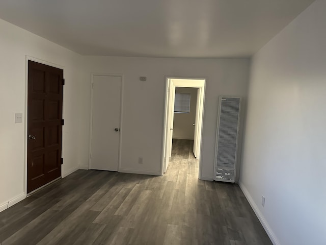 15284 Carol St, Mojave, CA 93501 - unfurnished room featuring a heating unit, dark wood-type flooring, and baseboards