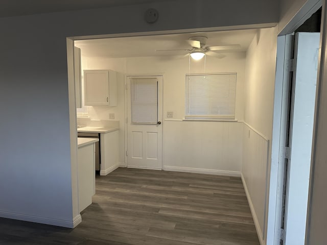 15284 Carol St, Mojave, CA 93501 - unfurnished dining area with a ceiling fan, dark wood-style flooring, wainscoting, and baseboards