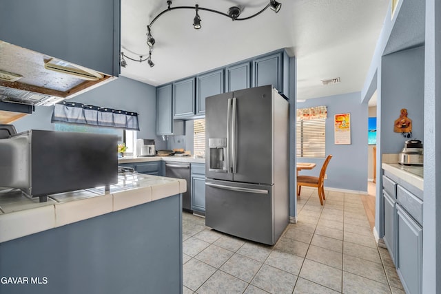 3628 Marilynn St, Lancaster, CA 93536 - kitchen featuring stainless steel fridge, tile counters, plenty of natural light, and light tile patterned flooring