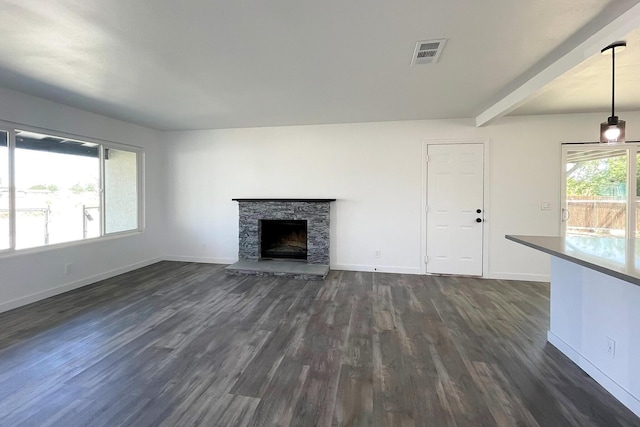 40294 Fieldspring St, Palmdale, CA 93591 - unfurnished living room featuring dark wood-type flooring, baseboards, a stone fireplace, and beamed ceiling