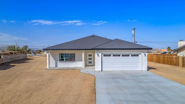 ranch-style house featuring driveway, a garage, a shingled roof, fence, and stucco siding