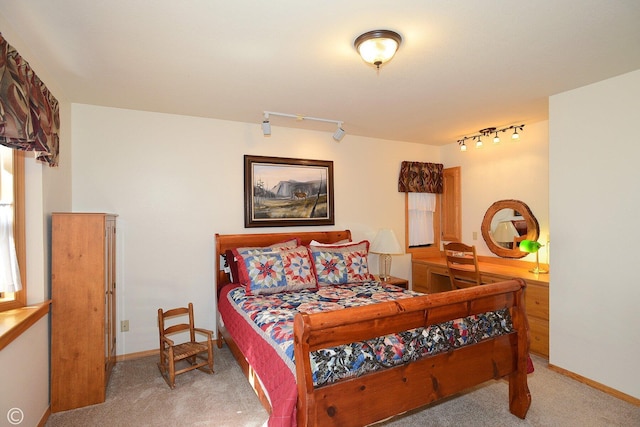 carpeted bedroom featuring track lighting