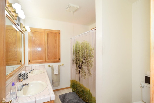 bathroom with vanity, a shower with shower curtain, and toilet