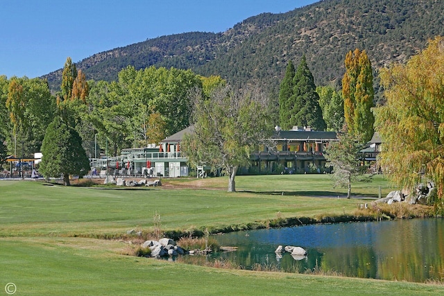 view of community featuring a water and mountain view and a lawn