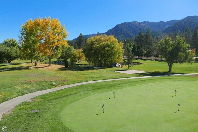 surrounding community featuring a lawn and a mountain view