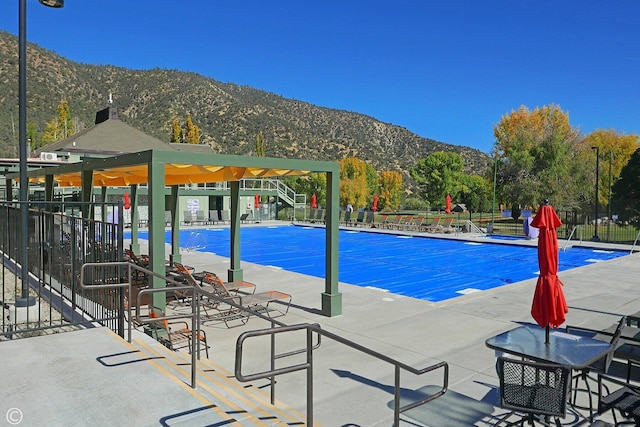 view of pool with a mountain view and a patio