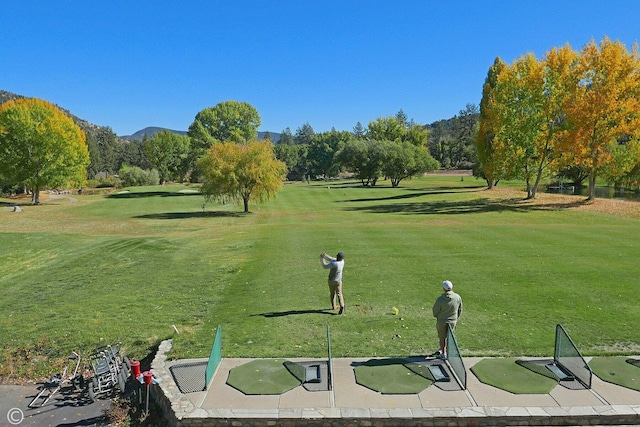 view of community with a mountain view and a lawn