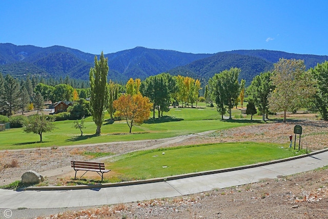 view of community with a lawn and a mountain view