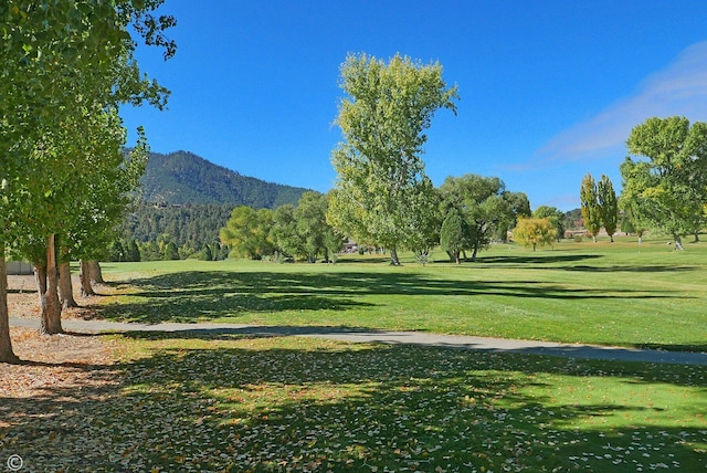 surrounding community featuring a lawn and a mountain view