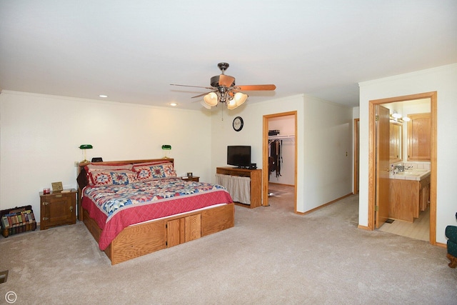 carpeted bedroom featuring ensuite bathroom, ornamental molding, ceiling fan, a spacious closet, and a closet