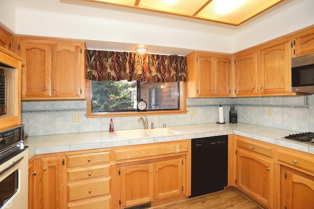 kitchen featuring black dishwasher, tasteful backsplash, wall oven, and sink