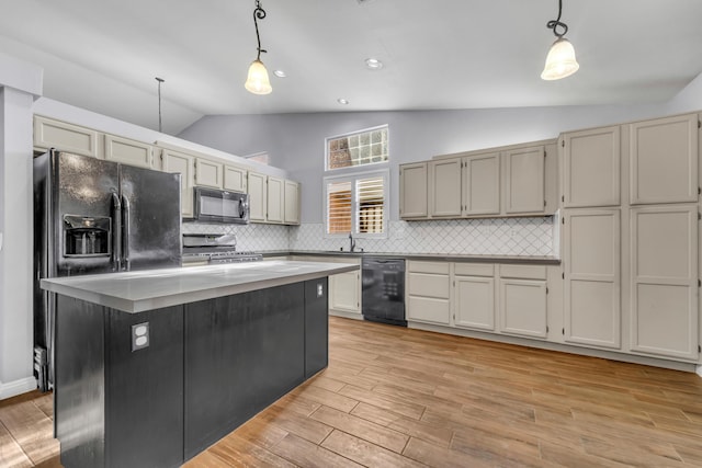 kitchen with backsplash, vaulted ceiling, black appliances, pendant lighting, and a kitchen island