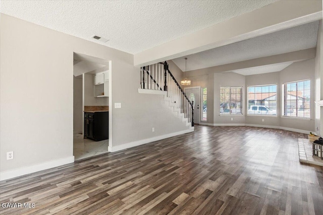 37623 E 49th St, Palmdale, CA 93552 - unfurnished living room featuring wood finished floors, stairs, a chandelier, and a textured ceiling