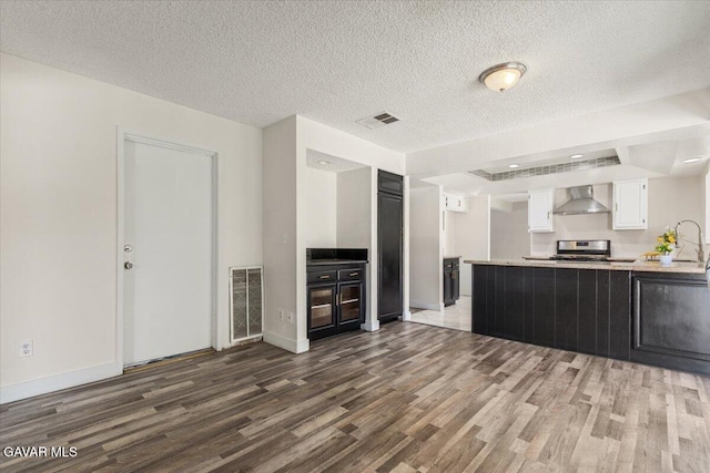 37623 E 49th St, Palmdale, CA 93552 - kitchen featuring wall chimney range hood, dark wood-style flooring, white cabinets, light countertops, and a textured ceiling