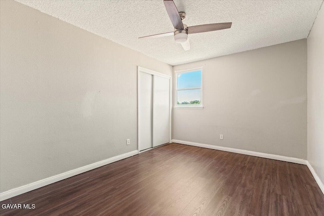 37623 E 49th St, Palmdale, CA 93552 - unfurnished bedroom with dark wood-style floors, a textured ceiling, a closet, and a ceiling fan