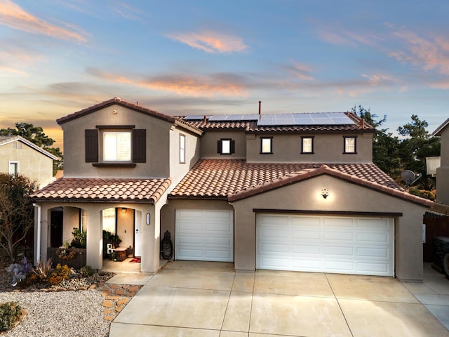 mediterranean / spanish-style home with a garage and solar panels