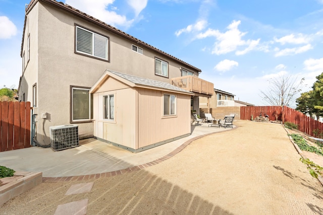 back of property with a patio area and central AC