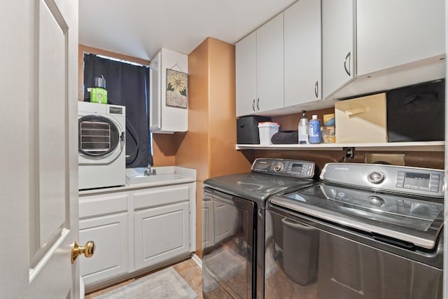 laundry area with sink, independent washer and dryer, and cabinets