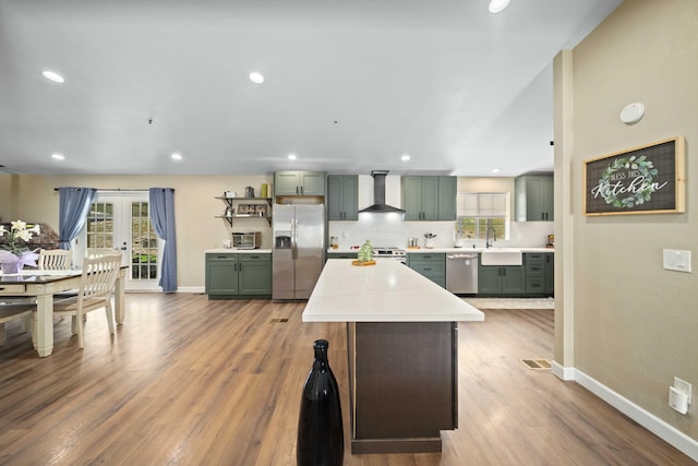 32722 Wagon Wheel Rd, Agua Dulce, CA 91390 - kitchen with appliances with stainless steel finishes, wall chimney range hood, green cabinets, a kitchen island, and light countertops