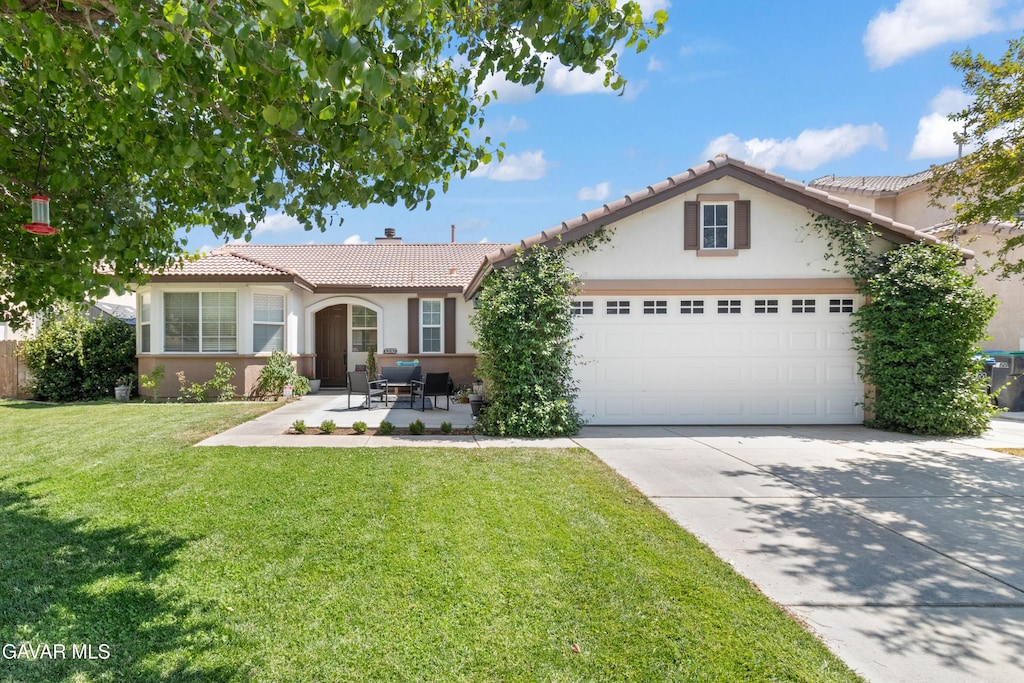 1232 W Ave H6, Lancaster, CA 93534 - view of front facade featuring an attached garage, stucco siding, a tiled roof, driveway, and a front lawn