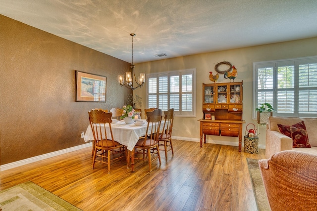 3216 Janine Ave, Rosamond, CA 93560 - dining room with wood finished floors, baseboards, a chandelier, and a textured wall