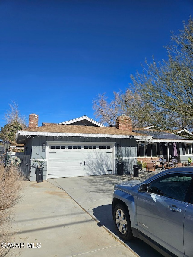 1283 W Lancaster Blvd, Lancaster, CA 93534 - view of front of house featuring a chimney, driveway, and a garage