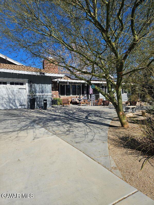 1283 W Lancaster Blvd, Lancaster, CA 93534 - view of front of home featuring a chimney and concrete driveway