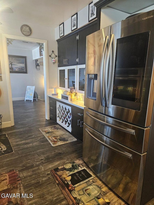 1283 W Lancaster Blvd, Lancaster, CA 93534 - kitchen featuring stainless steel refrigerator with ice dispenser, dark wood finished floors, and dark cabinetry