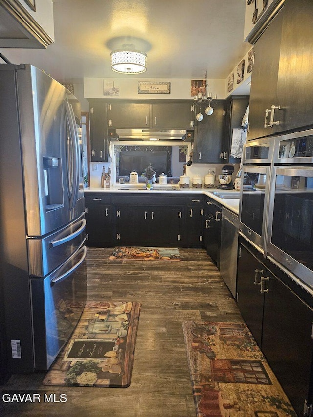 1283 W Lancaster Blvd, Lancaster, CA 93534 - kitchen with stainless steel appliances, dark wood-style flooring, under cabinet range hood, and light countertops