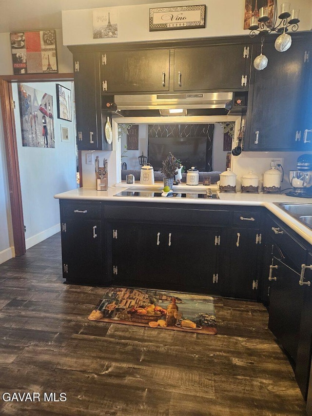 1283 W Lancaster Blvd, Lancaster, CA 93534 - kitchen featuring dark wood-type flooring, light countertops, under cabinet range hood, and black electric stovetop