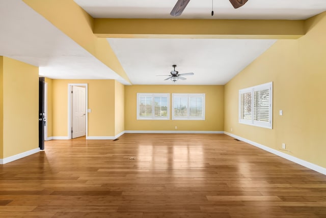 spare room featuring lofted ceiling, baseboards, a ceiling fan, and wood finished floors