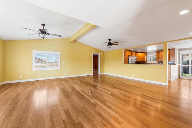 unfurnished living room with lofted ceiling with beams, light wood finished floors, ceiling fan, and baseboards