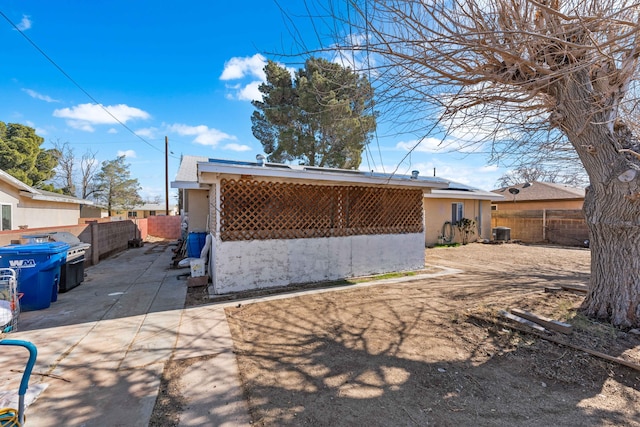 rear view of house with central AC and a patio