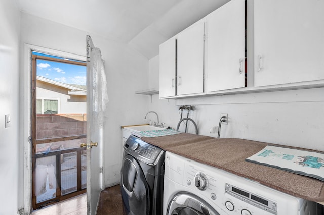 clothes washing area with washer and dryer, sink, and cabinets