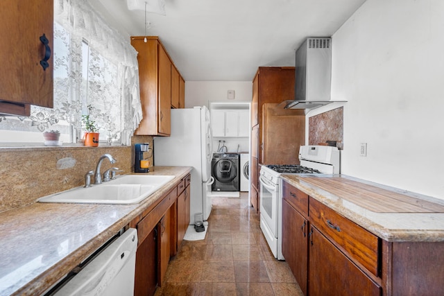 kitchen featuring washer and dryer, tasteful backsplash, sink, white appliances, and wall chimney exhaust hood