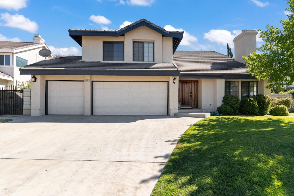 front facade featuring a garage and a front yard