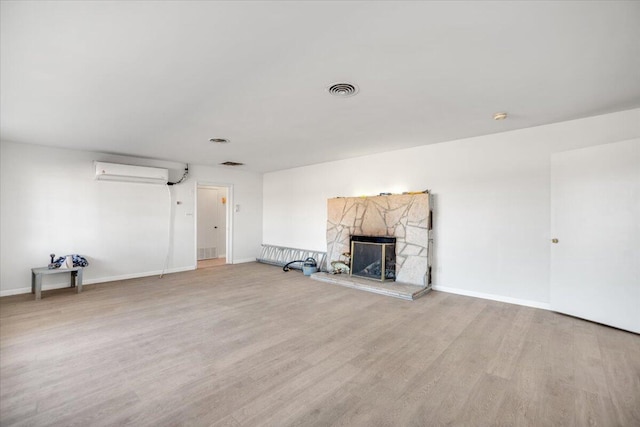 39441 E 140th St, Palmdale, CA 93591 - unfurnished living room with wood finished floors, a wall mounted AC, baseboards, and a fireplace