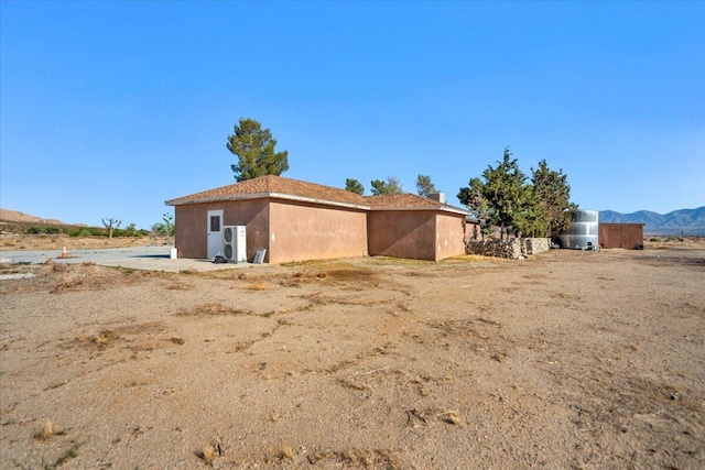 39441 E 140th St, Palmdale, CA 93591 - back of house featuring ac unit, stucco siding, and a mountain view